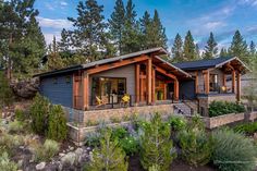 this is an image of a modern home in the woods, with lots of trees and shrubs around it