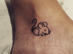 a small tattoo on the foot of a person with a mouse drawn on it's side