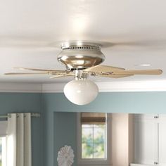 a ceiling fan in a bedroom with blue walls