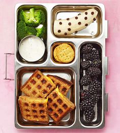 a bento box filled with different types of food and fruit on top of it