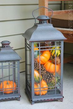 a lantern filled with pumpkins and pine cones