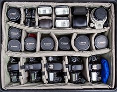 an open camera case filled with lots of different types of cameras in it's compartments