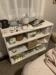 a white shelf with baskets and other items on it