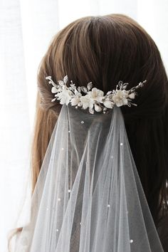 a veil with flowers and pearls on it