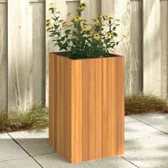 a tall wooden planter sitting on top of a cement floor next to a fence