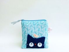 a small zippered pouch with a cat on the front and a bird on top