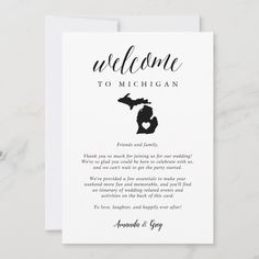 a welcome card with the silhouette of michigan in black and white, on a marble surface