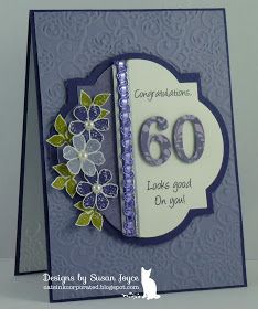 a close up of a greeting card with flowers on the front and an embellishment in the middle