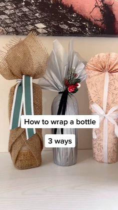 three wrapped gift bags sitting on top of a table next to each other with the words how to wrap a bottle 3 ways