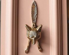 a pink door with a gold fox head on it