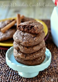 chocolate cookies stacked on top of each other in a blue bowl with cinnamon sticks next to them