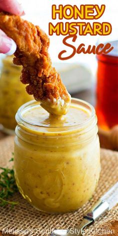 a person dipping something into a jar with the words honey mustard sauce on it and in the background