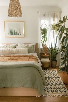 a bed sitting in a bedroom next to a plant on top of a wooden floor