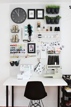 a sewing machine sitting on top of a white table next to a wall mounted clock