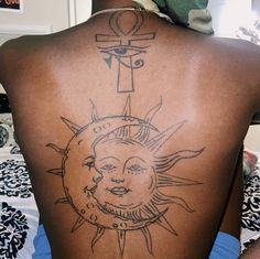 the back of a man with a tattoo on his upper body and sun behind him