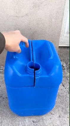 a person holding onto a blue plastic container