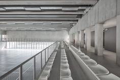 an empty parking garage filled with lots of white urinals on the side of it