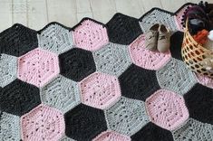 a crocheted blanket with shoes and a basket on the floor