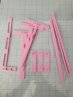 some pink plastic pieces are laying on a piece of graph paper and ready to be cut