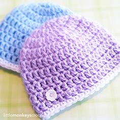 two crocheted hats sitting on top of a table