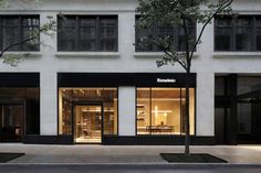 an empty street in front of a building with glass doors and windows on both sides