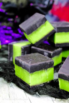 green and black desserts are stacked on top of each other in the shape of cubes