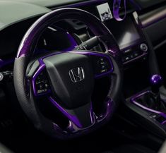 the interior of a car with purple trims and steering wheel cover, dashboard, and dash board