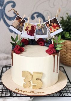 a decorated cake with photos hanging from the top