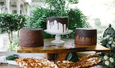 three different cakes sitting on top of a wooden table