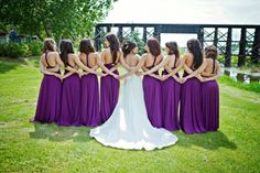 a group of women in purple dresses standing next to each other