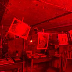 a room with red lights and pictures hanging from the ceiling