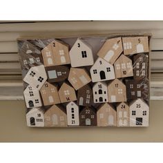 several wooden houses are stacked on top of each other in front of a window sill