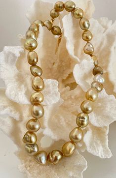 True Baroque shape 9-13mm Golden South Sea Cultured Pearl Necklace, 18" length. Baroque shaped cultured pearls are actually fairly rare to come by. Many dealers often use the word baroque instead of semi-baroque, which still hold a symmetrical structure to the pearl. A true baroque pearl can be compared to the shape of a potato. They make up usually less than one percent of the total harvest and command a higher price than the semi baroque which can amount to 20 to 30% of a harvest. Demand from connoisseurs for this type of pearl is high. Holding these pearls in your hand is like holding gold nuggets! The color is so vibrant! The color and luster for this necklace are very nice with an overall golden color.  The strand is professionally strung and knotted. Finished with a Hinged Clip 18k Y Yellow Gold Baroque Pearl Single Strand Necklace, Classic Baroque Pearl Necklace With High Luster, Yellow Gold Pearl Necklace With High Luster Baroque Pearls, Yellow Gold High Luster Baroque Pearl Necklace, High Luster Yellow Gold Pearl Necklace With Round Beads, High Luster Baroque Pearl Classic Necklace, Classic Baroque Pearl Necklaces With High Luster, Yellow Gold Pear-shaped Pearl Necklace With High Luster, Classic High Luster Baroque Pearl Necklaces