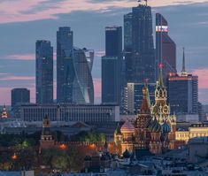 the city skyline is lit up at night with skyscrapers in the background and lights on