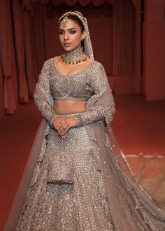 The embellished Bridal Grey Lehenga Choli and Dupatta Dress is a magnificent masterpiece that gives the gorgeous bride a head-turning appearance on the big day. Sequins, cut-dana, and embroidery work make this beautiful Lehenga Dress an epitome of beauty and grace. Choli: The beautifully embellished choli in an alluring grey shade is a stunning choice to pair with Lehenga. The choli comes in net fabric. Embroidery and naqshi give a royal touch to this beautiful choli. Cut-dana, pipes, and sequin Grey Lehenga Blouse Designs, Silver Lengha Bridal, Hussain Rehar, Grey Lehenga, Dupatta Dress, Beautiful Lehenga, Lehenga Dress, Lehenga Dupatta, Bridal Makeup Images