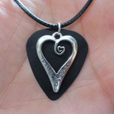 "Scrolled Heart Charm Guitar Pick Necklace Very Cute -- The overall length of the necklace is adjustable, approximately 18.25\"-19.75\" range -- The charm is made with a metal charm on a solid color guitar pick backer -- an eye catching look! The finished charm measures 1.25\"h x 1\" wide overall -- the charm hangs loose on the front of the guitar pick, so they rotate independently of one another -- The necklace cable is black 2mm dia. jewelry cord with crimped end connectors, high quality hardw Black Guitar Pick, Pick Necklace, Guitar Pick Necklace, Black Guitar, Hippie Girl, Hang Loose, Girl Jewelry, Pretty Necklaces, Metal Charm