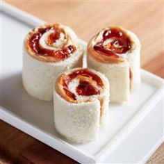 three pieces of sushi on a white plate