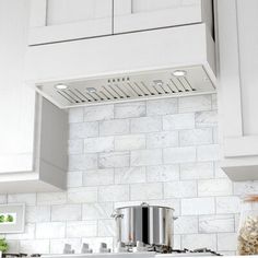 a stove top oven sitting inside of a kitchen next to white cabinets and counter tops