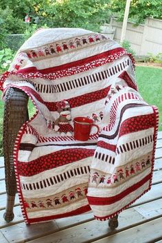 a chair with a blanket on top of it and a coffee cup in the middle