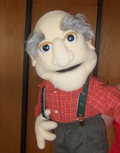 the puppet is wearing overalls and a red shirt