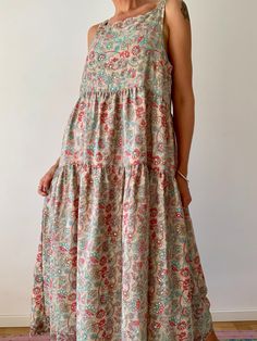 Extra loose, relaxed fitting flared long swing dress with floral prints and golden shimmer  It is perfect sleeveless summer dress for everyday wear or vacation trips  Great during maternity times will fit all ladies from 8-12 size MEASURE Shoulder 17" Bust 40" Length 50" MATERIAL * silk blended poliester  More boho style ideas at  https://www.etsy.com/shop/AltheaStores CARE INSTRUCTIONS  * Wash in warm water * Hand wash recommended * Hang to dry  IMPORTANT NOTE  * Please note that colour shown o Summer Vacation Tiered Maxi Dress, Summer Maxi Tiered Dress, Casual Summer Tiered Maxi Dress, Flowy Bohemian Tiered Dress For Vacation, Bohemian Floral Print Tiered Dress For Beach, Beige Tiered Maxi Dress For Vacation, Bohemian Tiered Dress With Floral Print For Beach, Bohemian Flowy Tiered Dress For Garden Party, Flowy Bohemian Tiered Dress For Garden Party