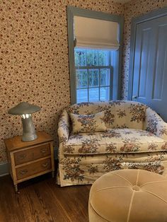 a living room filled with furniture and a lamp on top of a hard wood floor