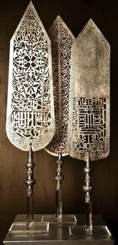 two metal utensils with arabic writing on them