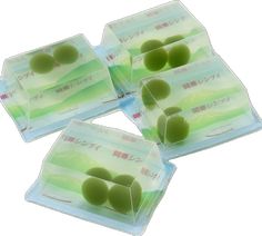 four pieces of green olives sitting on top of each other in plastic packaging with japanese writing