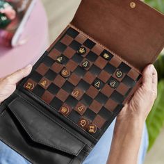 a person holding up a brown and black checkerboard case with buttons on it