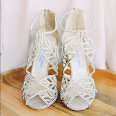 a pair of white shoes sitting on top of a wooden table