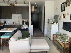 a living room filled with furniture next to a kitchen