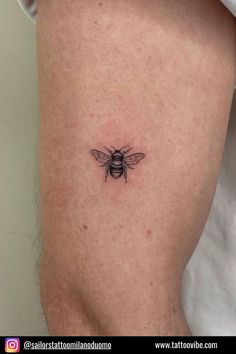 a small bee tattoo on the thigh