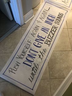 a sign that is on the ground in front of a door with words written on it