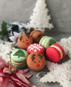 christmas cookies decorated with icing and decorations on top of snow covered ground next to small trees